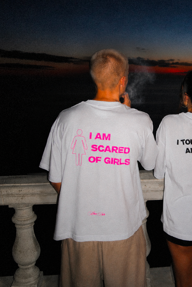 Modello indossa la t-shirt oversize bianca I AM SCARED OF GIRLS di 4AM Season con grafica rosa sul retro