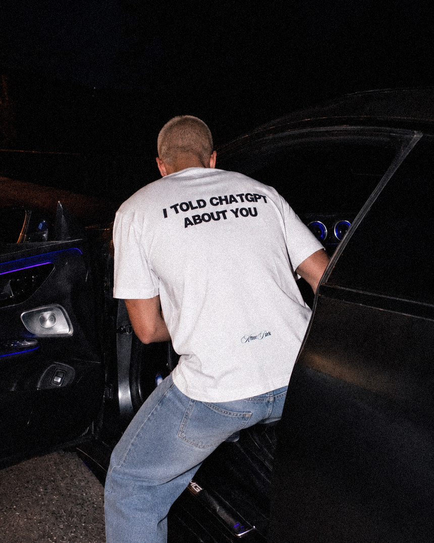 Modello indossa la t-shirt oversize bianca I TOLD CHATGPT ABOUT YOU di 4AM Season con stampa blu scuro sul retro